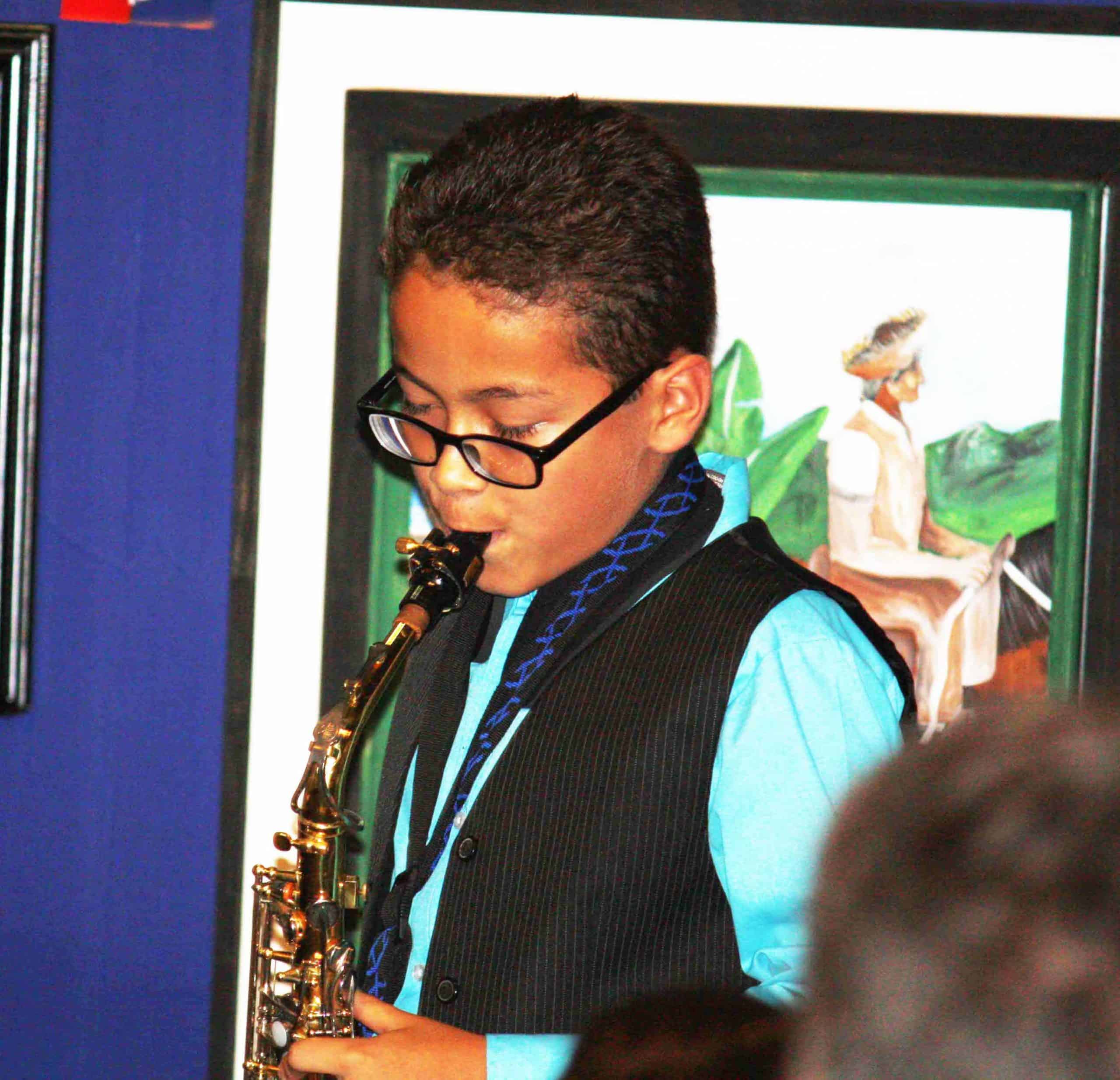 Young boy learning how to play the saxophone.